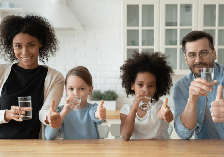 Four people each drinking a glass of water